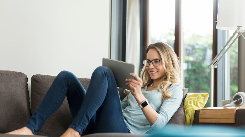 Frau mit Tablet auf Couch