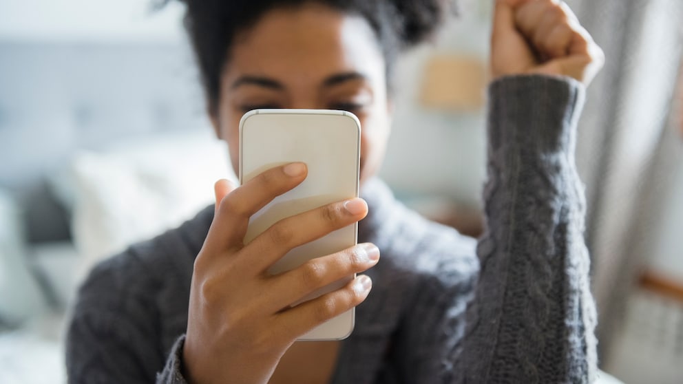Frau mit Smartphone in Feier-Pose