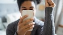Frau mit Smartphone in Feier-Pose