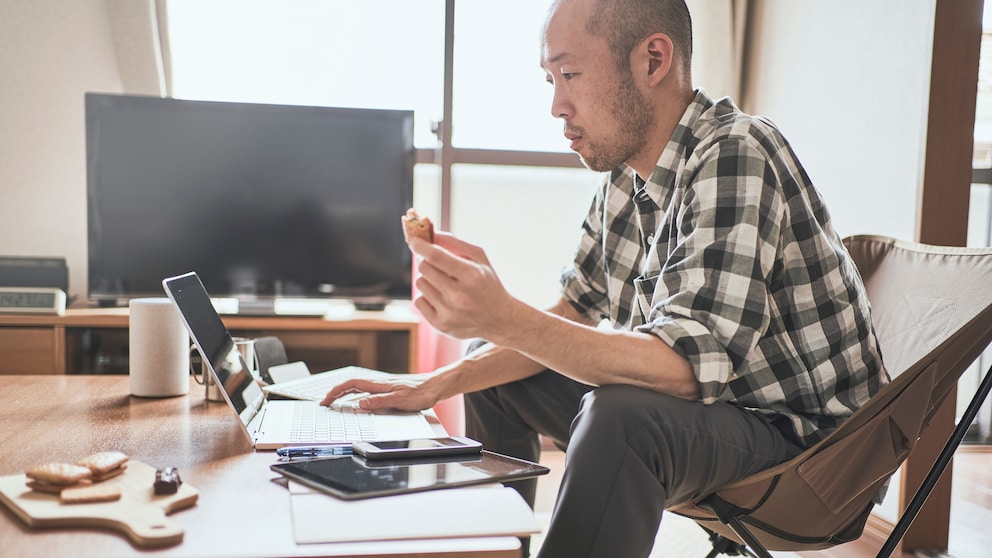 Cookies neue Regelung Symbolbild: Mann sitzt mit Keks vor seinem Computer