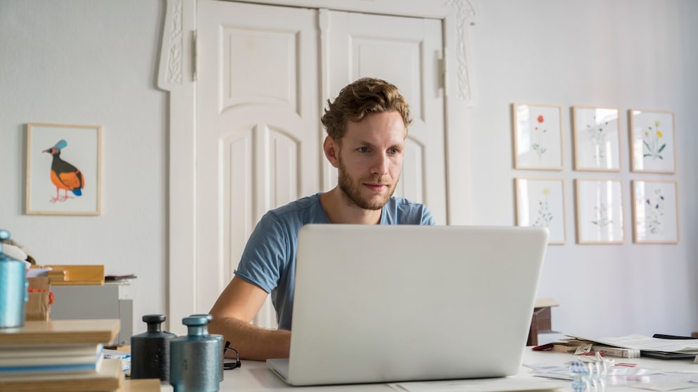 Symbolbild Gmail mit anderen Konten verknüpfen: Junger Mann am Laptop