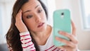 Frau mit Smartphone gestresst