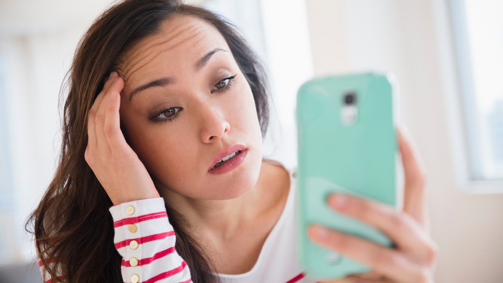 Frau mit Smartphone gestresst