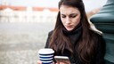 Frau schaut verärgert aufs Smartphone