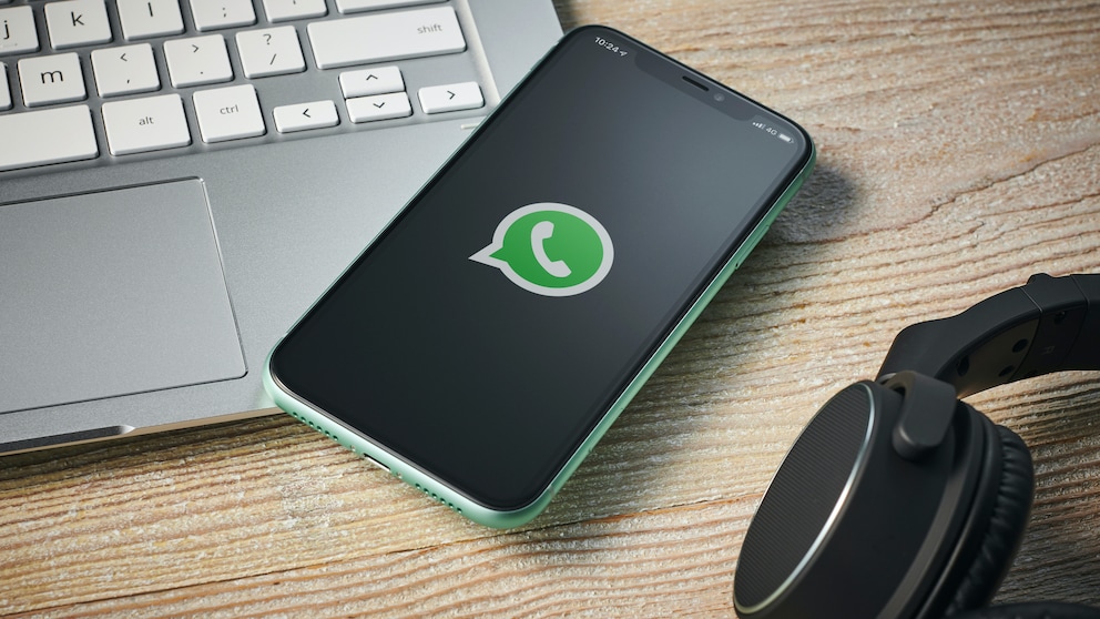 WhatsApp Passwort: Smartphone mit WhatsApp-Logo liegt auf Laptop