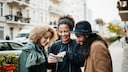 Drei Freunde mit Smartphone
