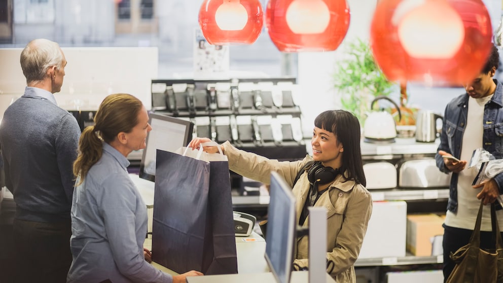Frau kauft im Elektronikmarkt ein