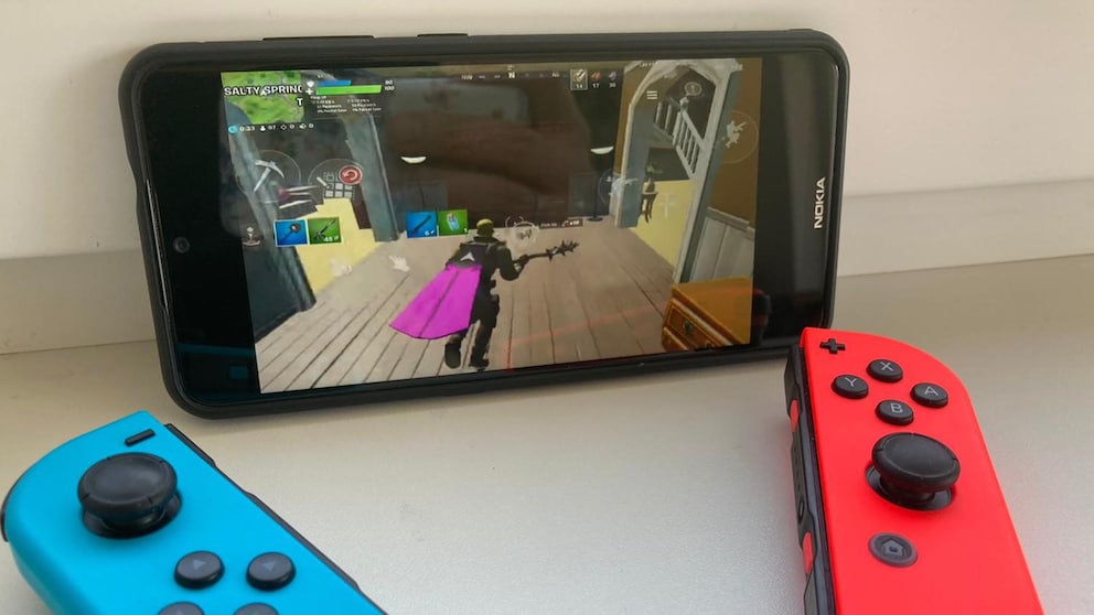 Controller mit Smartphone verbinden: Nintendo Switch Joy Cons rot blau liegen vor Smartphone