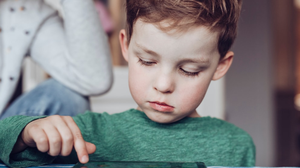 Kleiner Junge tippt auf Tablet