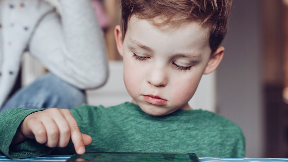 Kleiner Junge tippt auf Tablet