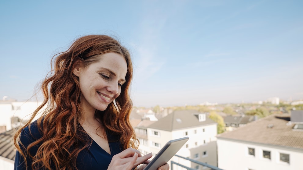Frau mit Tablet auf dem Balkon