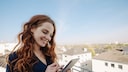 Frau mit Tablet auf dem Balkon