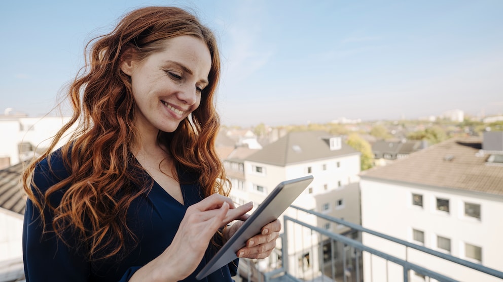 Frau mit Tablet auf dem Balkon