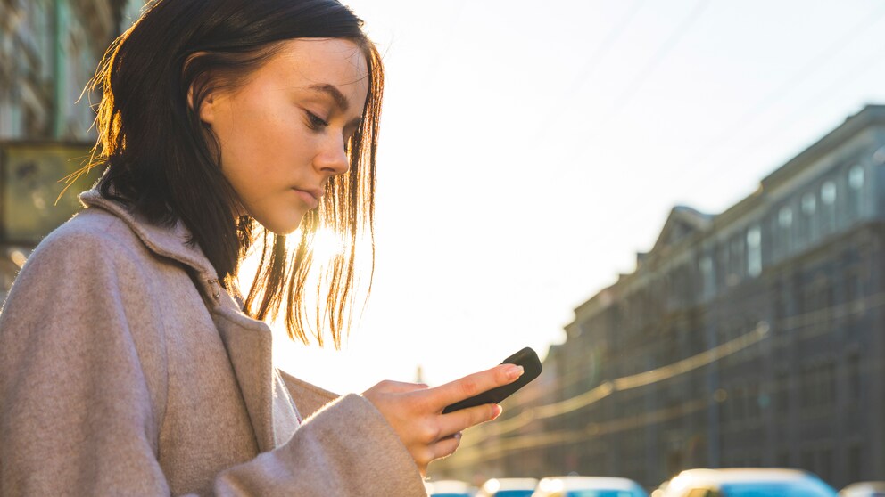 Frau mit Smartphone auf der Straße