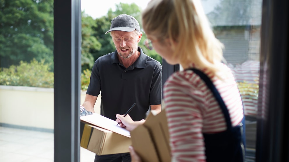 Frau bekommt ein Paket vom Paketboten