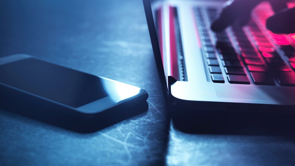 Hacker mit Laptop und Handy