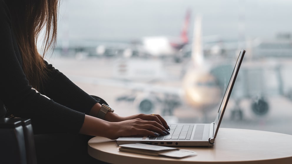 Frau arbeitet mit Laptop am Flughafen