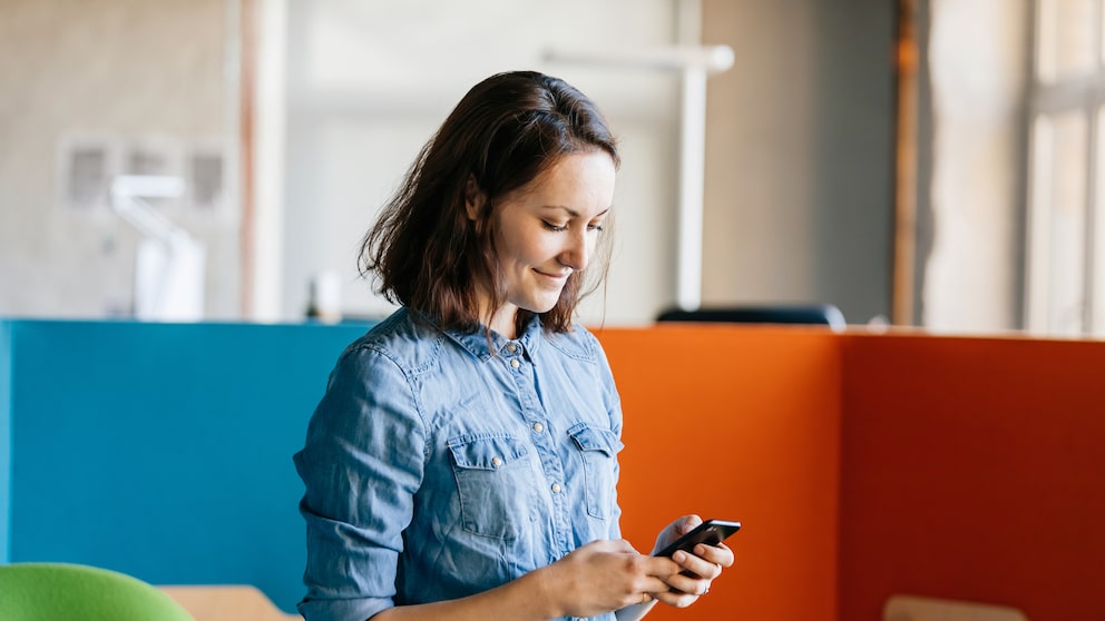 Frau mit Smartphone im Büro