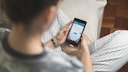 Frau chattet mit WhatsApp übers Smartphone