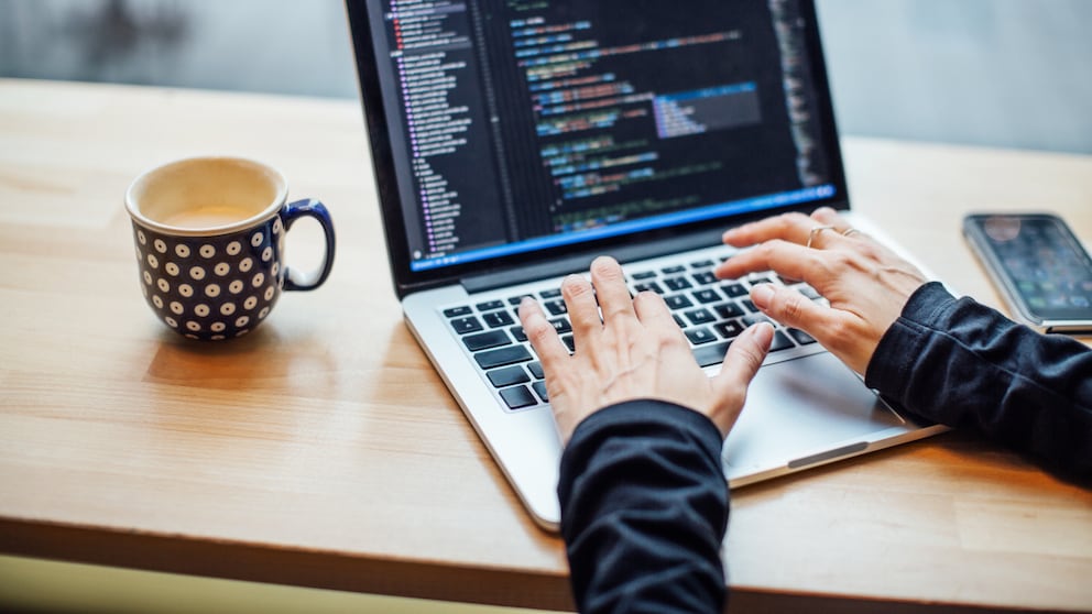 Frau am Laptop mit HTML-Code