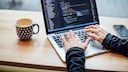 Frau am Laptop mit HTML-Code