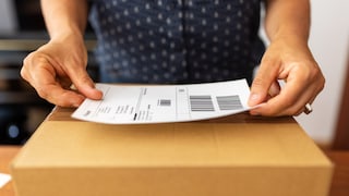 Frau frankiert ein Paket