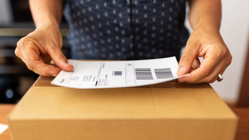 Frau frankiert ein Paket