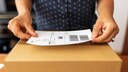 Frau frankiert ein Paket
