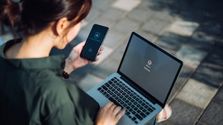 Frau versucht sich am MacBook einzuloggen