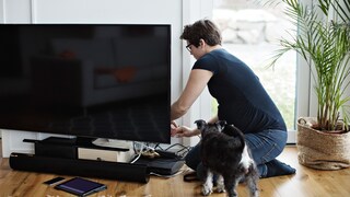 Frau schließt Fernseher an