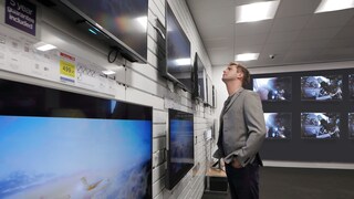 Man im Elektronikladen vor den Fernsehern