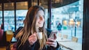 Frau im Café mit Smartphone