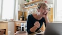 Frau lachend vor Laptop