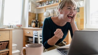 Frau lachend vor Laptop