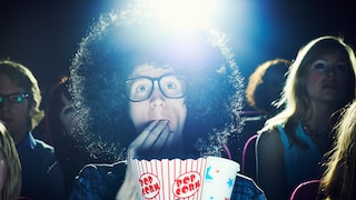 Mann im Kino mit Popcorn