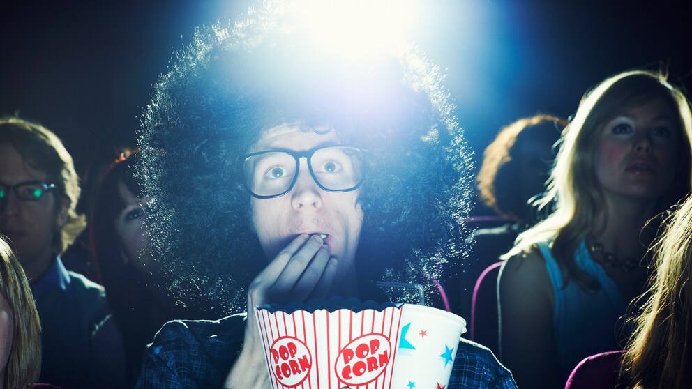 Mann im Kino mit Popcorn