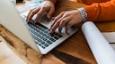 Suche im Internet Symbolbild: Nahaufnahme eines Laptops, an dem jemand arbeitet