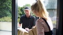 DHL Versand Zug: Frau nimmt Paket an