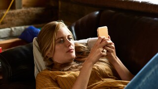 Instagram Story Funktion: junge Frau mit Handy auf dem Sofa
