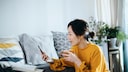 Rente mit Apps auf dem Smartphone verbessern: Frau mit Handy trinkt Kaffee