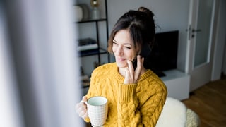 Frau am Fenster telefoniert