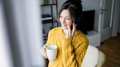 Frau am Fenster telefoniert