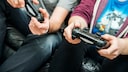 Konsole kühlen: Zwei Männer spielen zusammen PlayStation