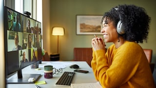 Frau chattet am PC per Video mit Kollegen