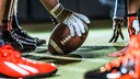 Football in Hand auf Spielfeld: NFL-Spiele im Stream