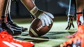 Football in Hand auf Spielfeld: NFL-Spiele im Stream