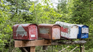 Alte abgenutzte Briefkästen auf einem Balken. Auch das E-Mail-Postfach muss vor Überfüllung geschützt werden.