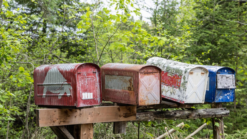 Alte abgenutzte Briefkästen auf einem Balken. Auch das E-Mail-Postfach muss vor Überfüllung geschützt werden.