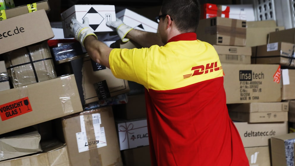 DHL-Fahrer sortiert Pakete