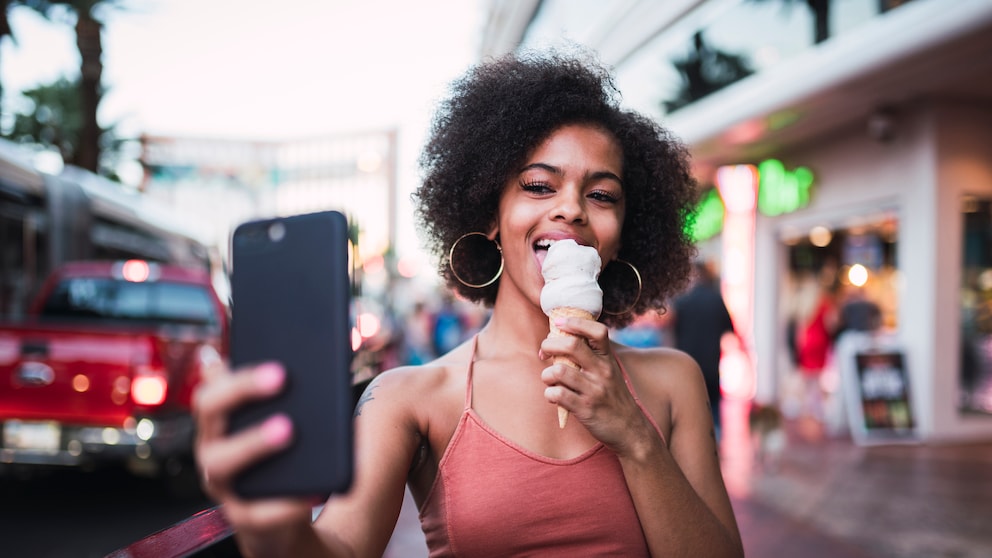 Instagram Standort deaktivieren: Frau macht Selfie beim Eisessen